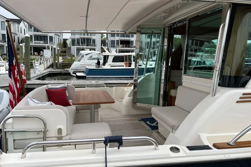 Slide: The Image of 2022 Sabre 45 Salon Express yacht docked by autumn trees. - 6