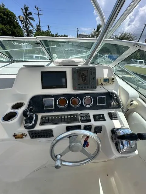 Slide: The Image of 2005 Wellcraft 290 Coastal boat dashboard with steering wheel and navigation instruments. - 12