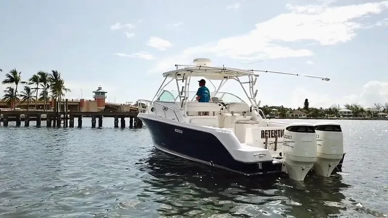 Slide: The Image of 2005 Wellcraft 290 Coastal boat on water near a dock with palm trees. - 2