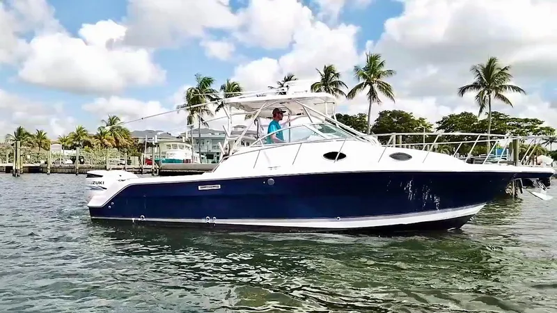 Slide: The Image of 2005 Wellcraft 290 Coastal boat cruising on water with palm trees in background. - 4