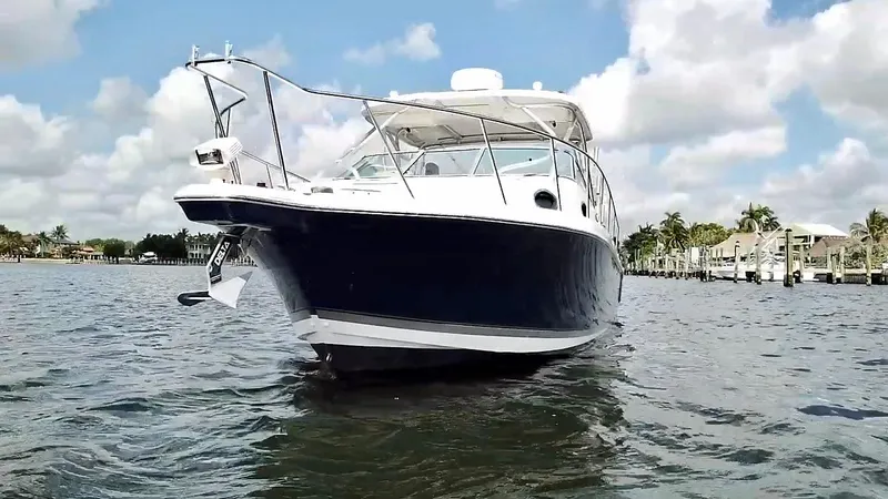 Slide: The Image of 2005 Wellcraft 290 Coastal boat on water, clear sky, palm trees in background. - 6