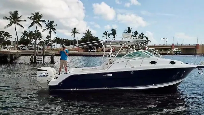 Slide: The Image of 2005 Wellcraft 290 Coastal boat on water, palm trees and dock in background. - 8