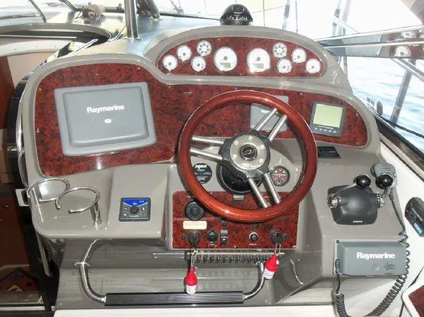 Slide: The Image of 2009 Regal Commodore 4060 helm with Raymarine electronics and wood-trimmed steering wheel. - 11