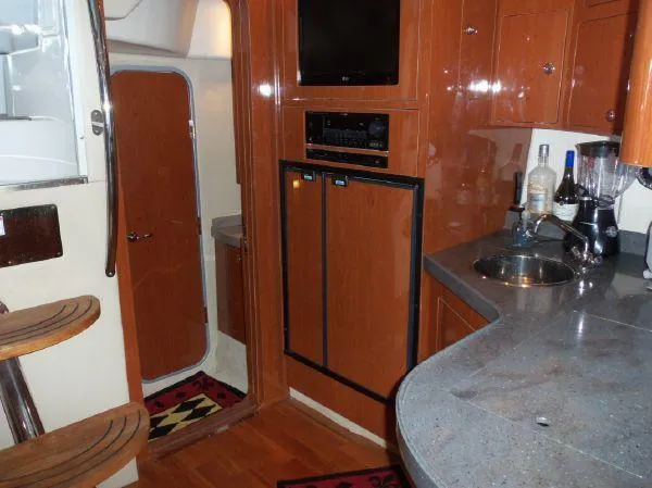 Slide: The Image of Interior of 2009 Regal Commodore 4060 yacht with kitchenette and wooden cabinetry. - 16