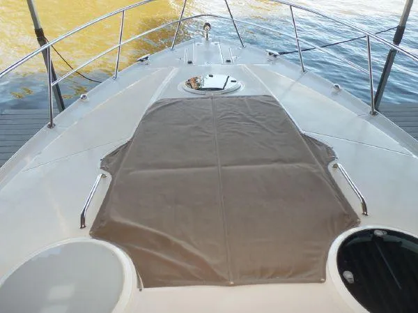 Slide: The Image of 2009 Regal Commodore 4060 yacht deck with sunpad, surrounded by water. - 26