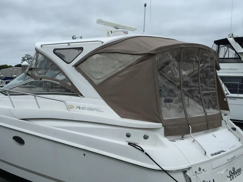 Slide: The Image of 2009 Regal Commodore 4060 yacht with beige canopy, docked in a marina. - 4