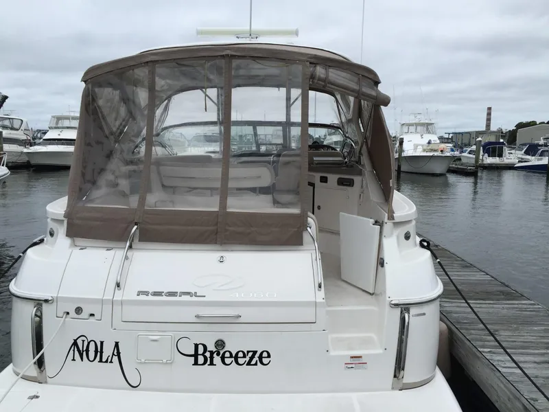 Slide: The Image of 2009 Regal Commodore 4060 yacht docked, featuring "NOLA Breeze" name on stern. - 5
