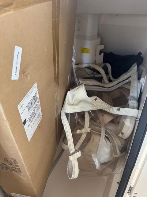 Slide: The Image of Storage compartment with cardboard box and clear plastic bags on Grady-White Freedom 275 boat. - 17