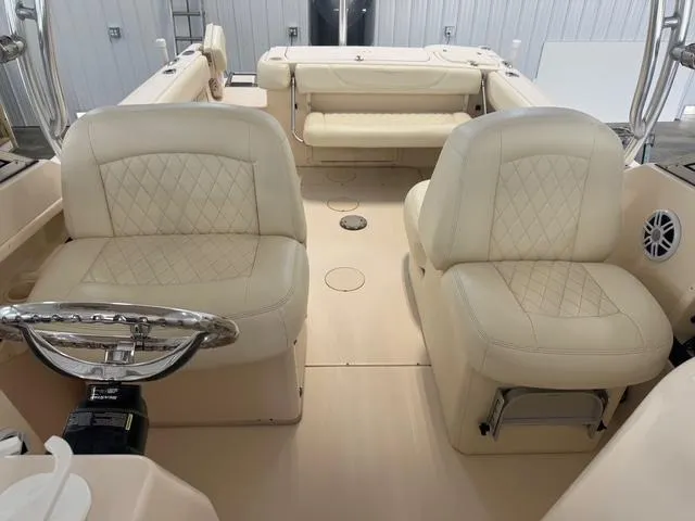 Slide: The Image of 2011 Grady-White Freedom 275 boat interior with beige leather seating and steering wheel. - 20