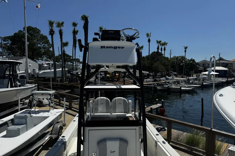 Slide: The Image of 2023 Ranger 2510 Bay boat docked at a marina with palm trees in the background. - 10