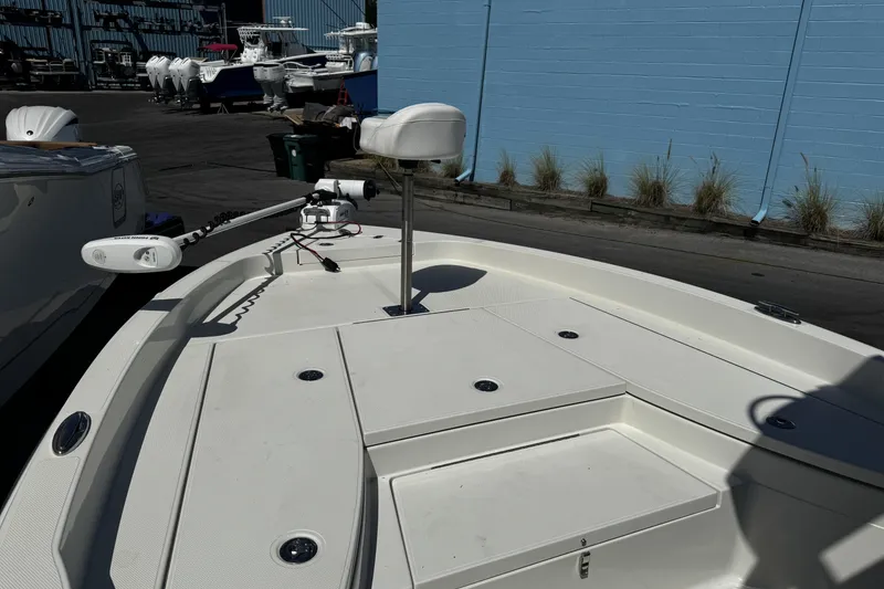 Slide: The Image of 2023 Ranger 2510 Bay boat deck with trolling motor, docked near blue wall. - 11