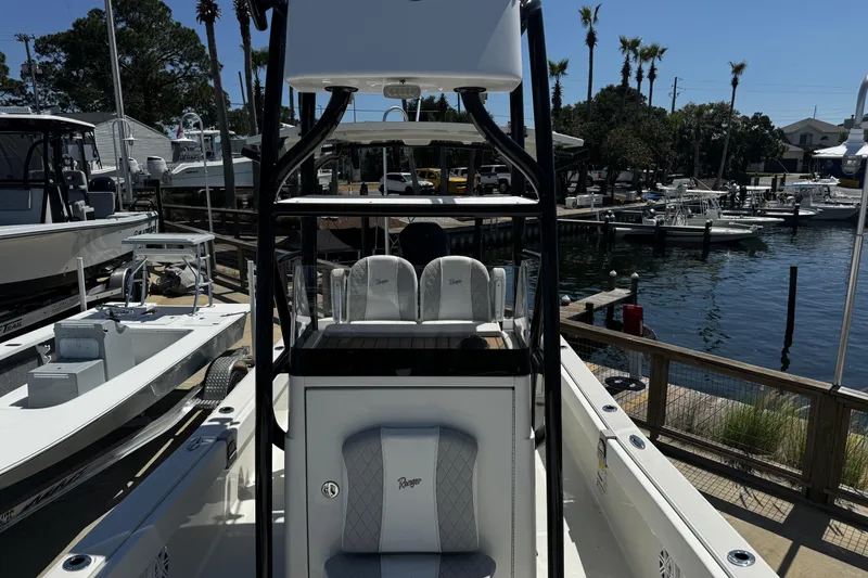 Slide: The Image of 2023 Ranger 2510 Bay boat docked at a marina with other boats nearby. - 16