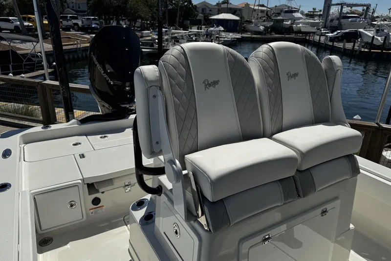 Slide: The Image of 2023 Ranger 2510 Bay boat with dual cushioned seats, docked at a marina. - 18