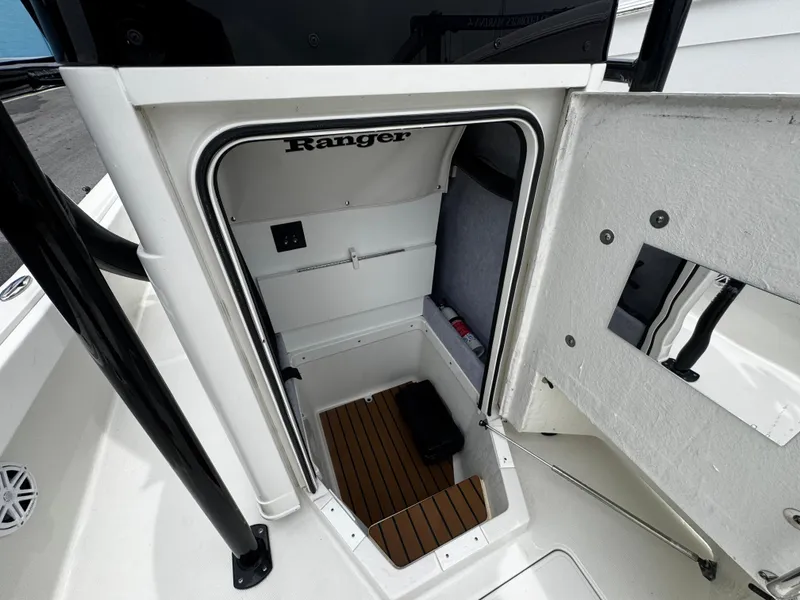 Slide: The Image of 2023 Ranger 2510 Bay boat storage compartment with wood flooring and interior features. - 24