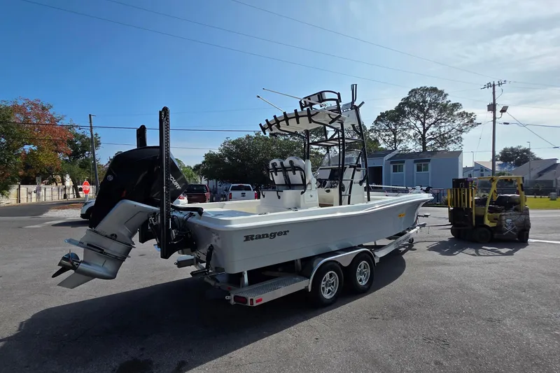 Slide: The Image of 2023 Ranger 2510 Bay boat on trailer, parked outdoors under clear sky. - 3