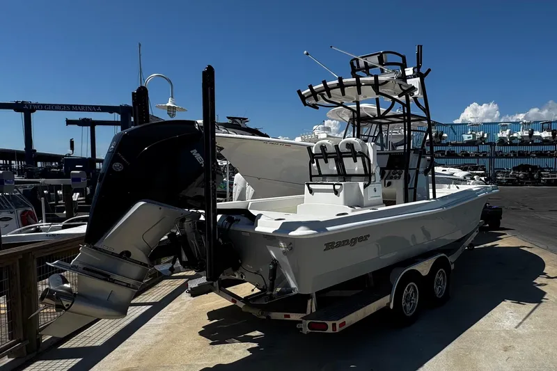 Slide: The Image of 2023 Ranger 2510 Bay boat on trailer at marina, featuring powerful outboard motor. - 6