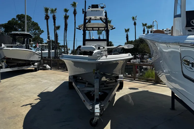 Slide: The Image of 2023 Ranger 2510 Bay boat on trailer, surrounded by palm trees and other boats. - 7