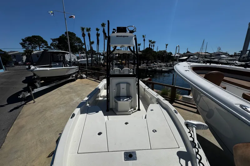 Slide: The Image of 2023 Ranger 2510 Bay boat docked, showcasing spacious deck and sleek design. - 9