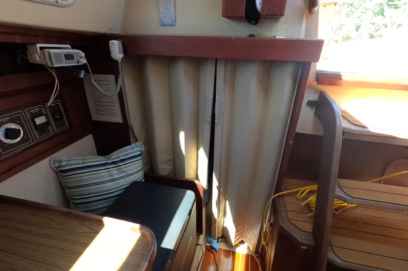 Slide: The Image of Interior of a 1983 Catalina 36 sailboat with radio, striped pillow, and wooden accents. - 15