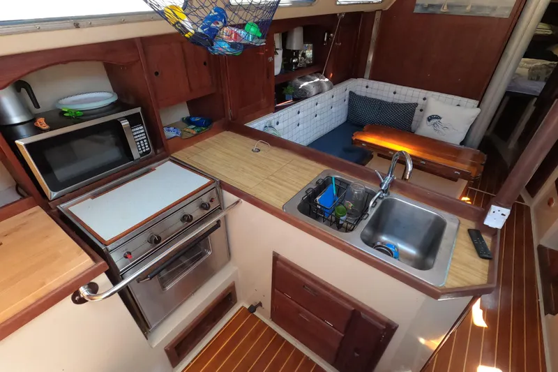 Slide: The Image of Interior of a 1983 Catalina 36 sailboat featuring a compact kitchen and cozy seating area. - 16