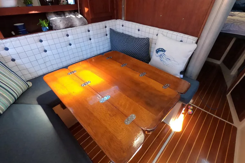 Slide: The Image of Cozy interior of 1983 Catalina 36 sailboat with wooden table and cushioned seating. - 26