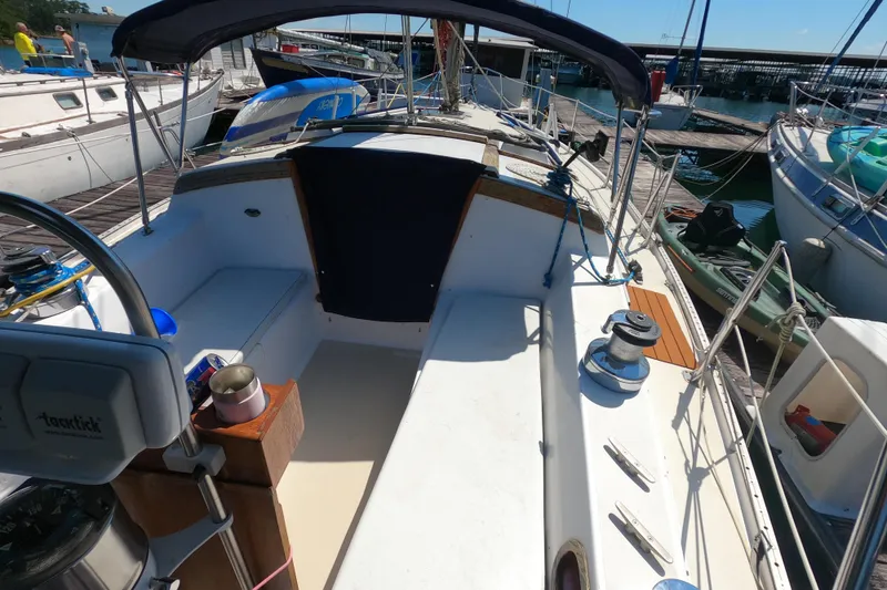 Slide: The Image of 1983 Catalina 36 sailboat cockpit with steering wheel, docked at marina. - 8