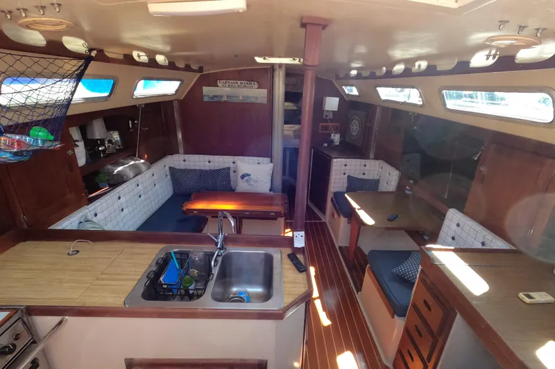 Slide: The Image of Interior of a 1983 Catalina 36 sailboat with cozy seating and wooden finishes. - 9
