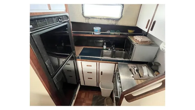 Slide: The Image of 1986 Carver 3607 Aft Cabin bathroom with toilet, mirror, and storage cabinet. - 13