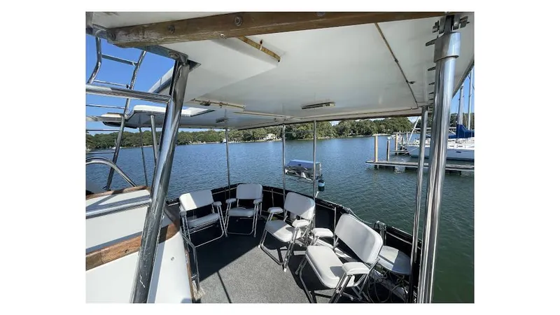 Slide: The Image of 1986 Carver 3607 Aft Cabin boat deck with chairs, overlooking serene marina waters. - 2