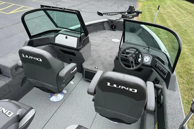 Slide: The Image of 2026 Lund 2075 Impact XS Sport boat interior with steering wheel and seating. - 10
