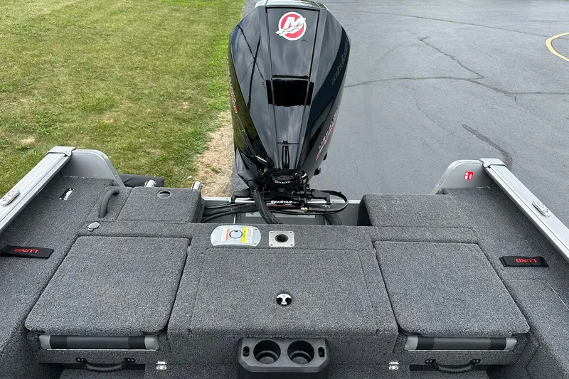 Slide: The Image of 2026 Lund 2075 Impact XS Sport boat with outboard motor, carpeted deck, and storage compartments. - 13