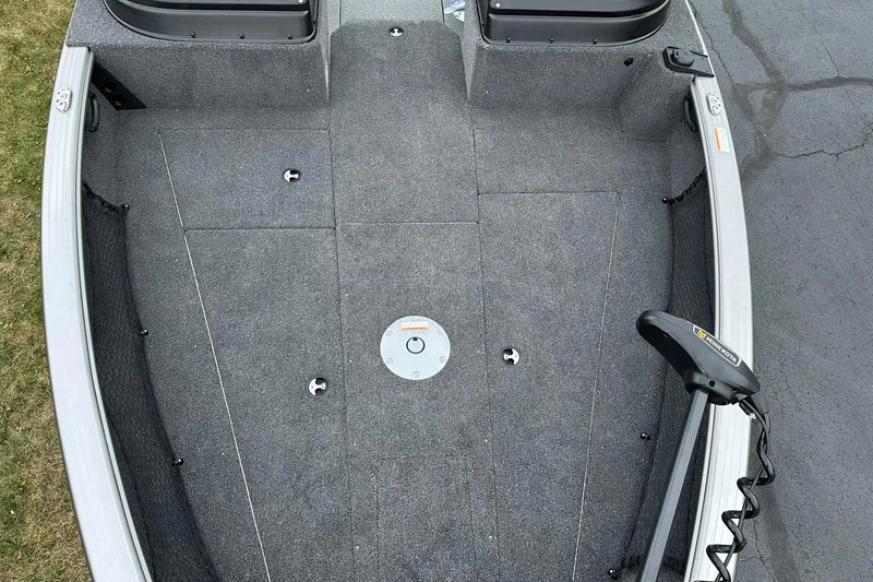 Slide: The Image of 2026 Lund 2075 Impact XS Sport boat deck with gray carpeting and trolling motor. - 16