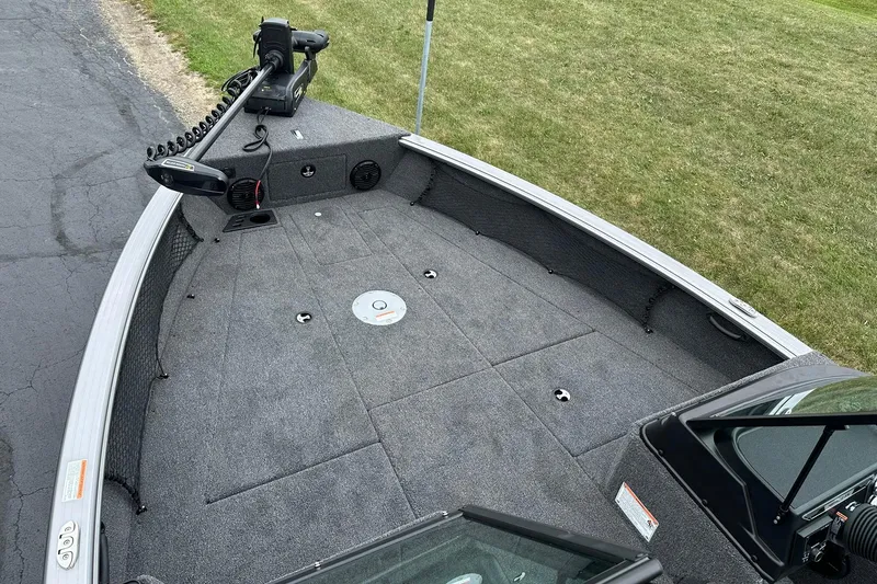 Slide: The Image of 2026 Lund 2075 Impact XS Sport boat deck with trolling motor, parked on pavement. - 17