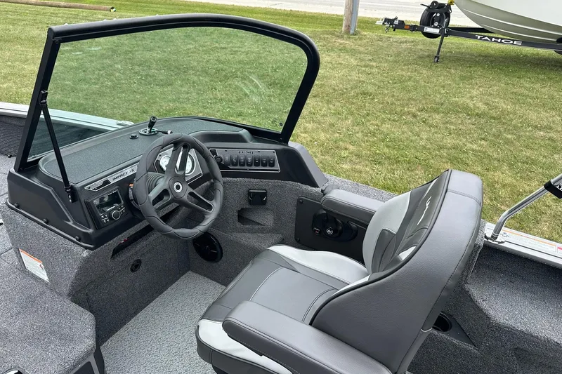 Slide: The Image of 2026 Lund 2075 Impact XS Sport boat interior with steering wheel and seating. - 19