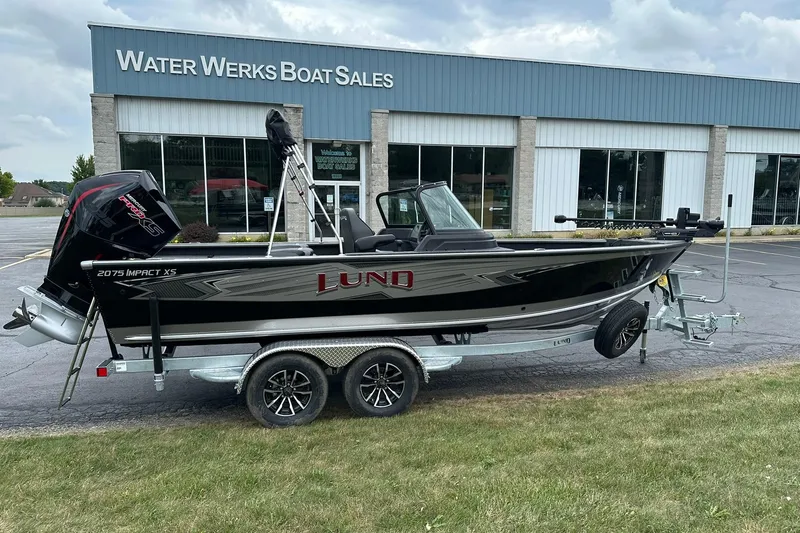 Slide: The Image of 2026 Lund 2075 Impact XS Sport boat on trailer at Water Werks Boat Sales. - 2