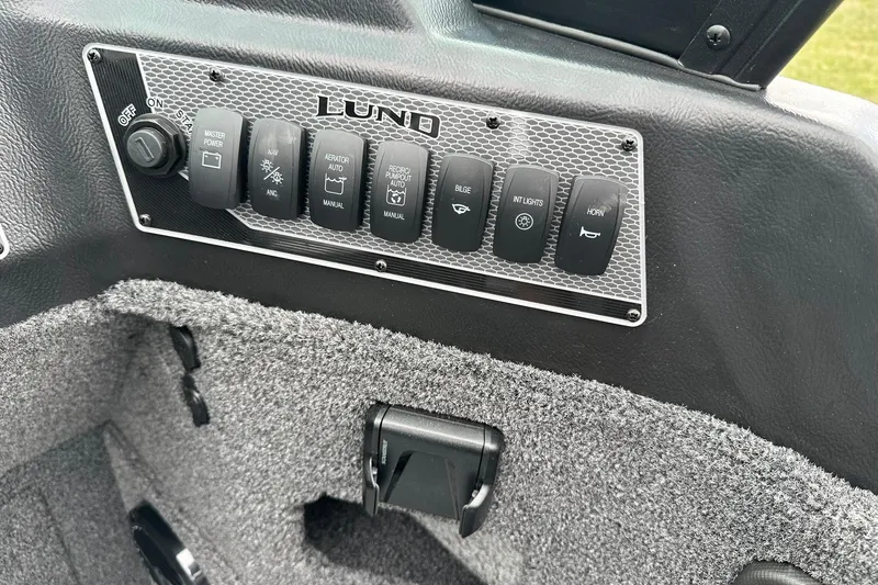 Slide: The Image of Control panel of 2026 Lund 2075 Impact XS Sport boat with various switches. - 21