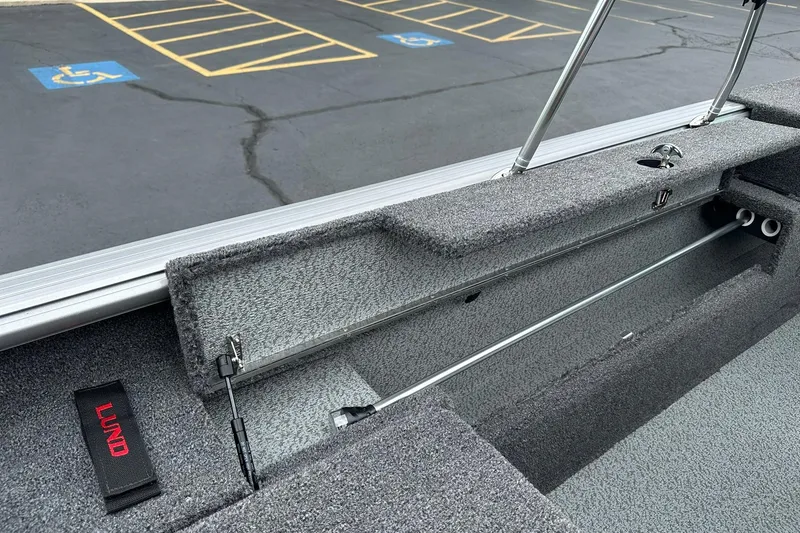 Slide: The Image of Interior view of 2026 Lund 2075 Impact XS Sport boat, showcasing storage compartment and seating area. - 29