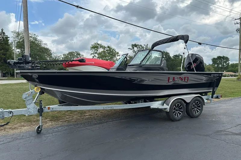 Slide: The Image of 2026 Lund 2075 Impact XS Sport boat on trailer, parked outdoors under cloudy sky. - 3