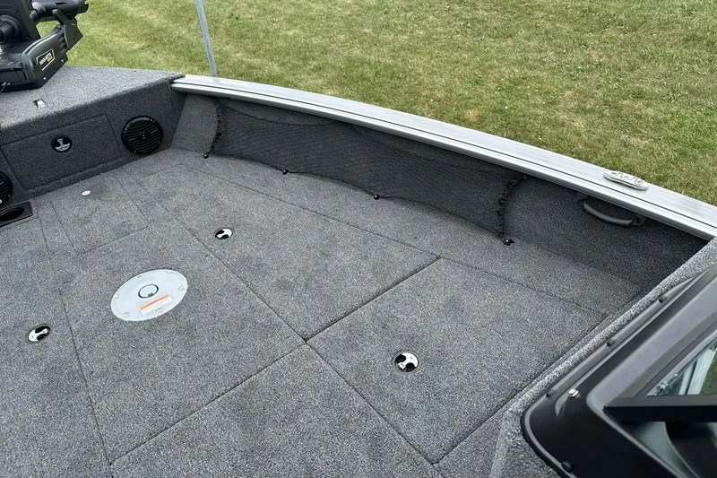 Slide: The Image of 2026 Lund 2075 Impact XS Sport boat interior with gray carpeted deck and storage compartments. - 30