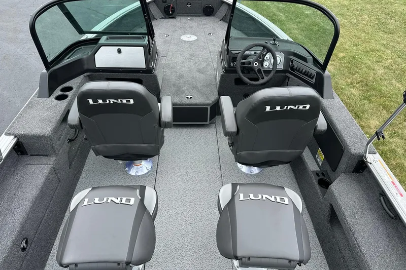 Slide: The Image of 2026 Lund 2075 Impact XS Sport boat interior with two branded seats and steering console. - 7