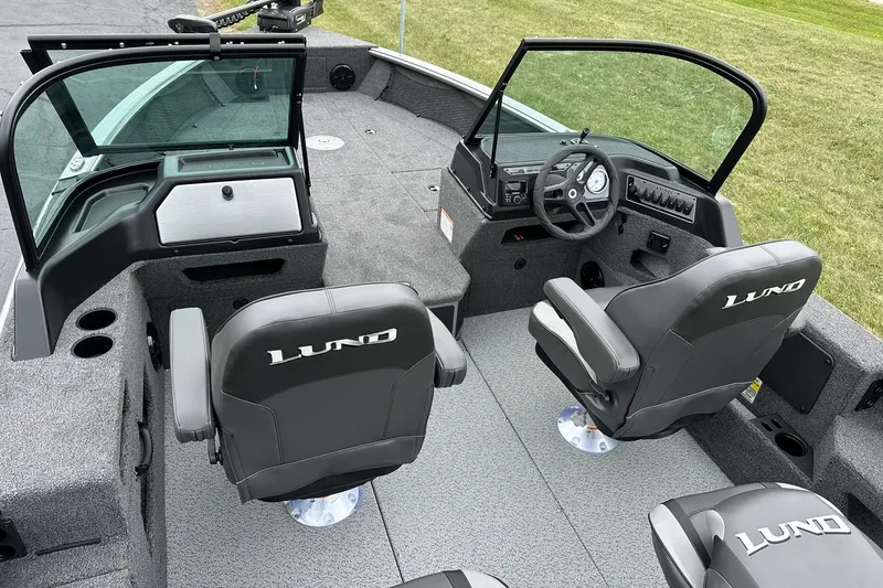Slide: The Image of 2026 Lund 2075 Impact XS Sport boat interior with steering wheel and seating. - 9