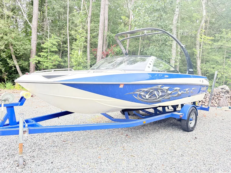 The Image of 2007 Malibu Wakesetter VTX boat on trailer, parked in a wooded area. - 1