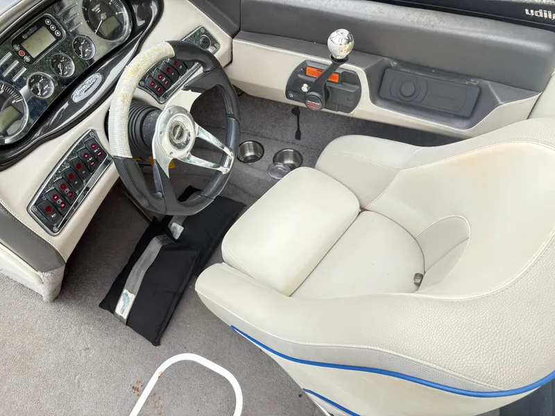 Slide: The Image of 2007 Malibu Wakesetter VTX boat interior with steering wheel, dashboard, and white captain's seat. - 12