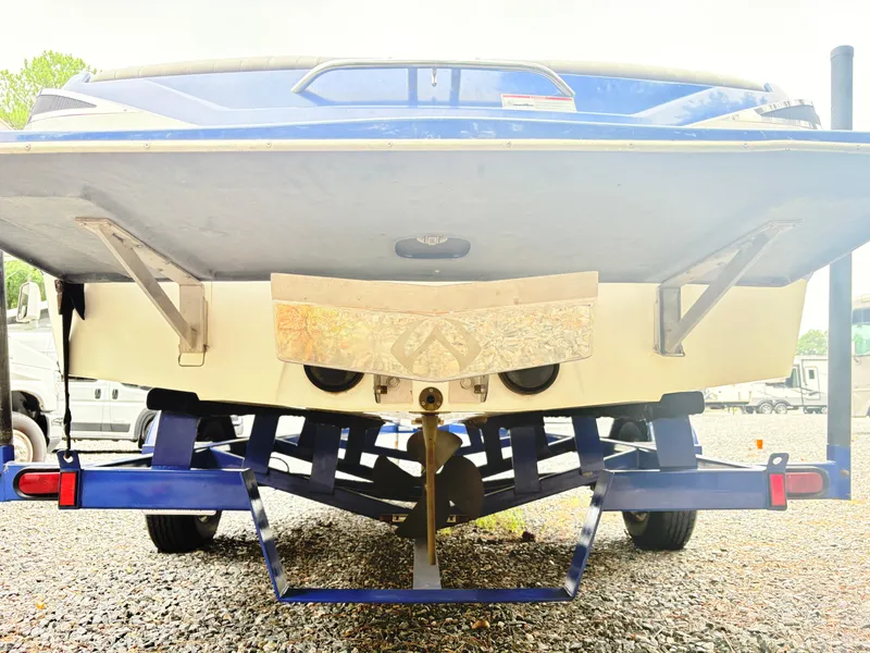 Slide: The Image of 2007 Malibu Wakesetter VTX boat on trailer, rear view, parked on gravel. - 4