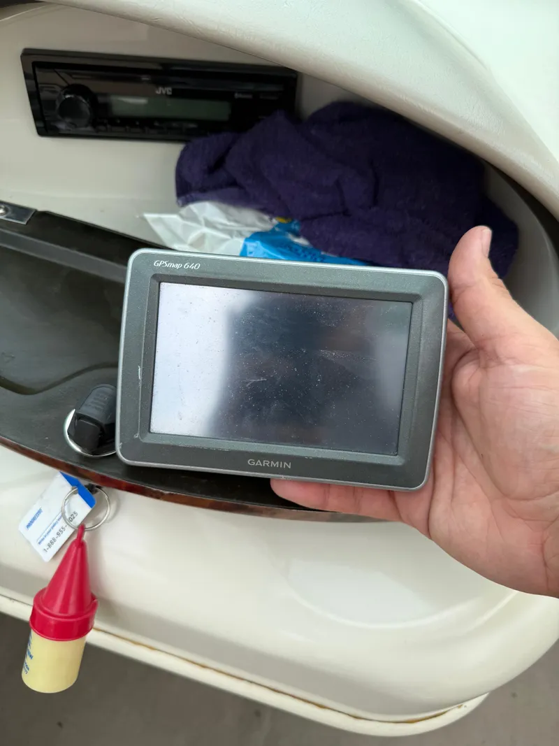 Slide: The Image of Hand holding Garmin GPS device on 2002 Sea Ray 176 Bow Rider boat dashboard. - 18