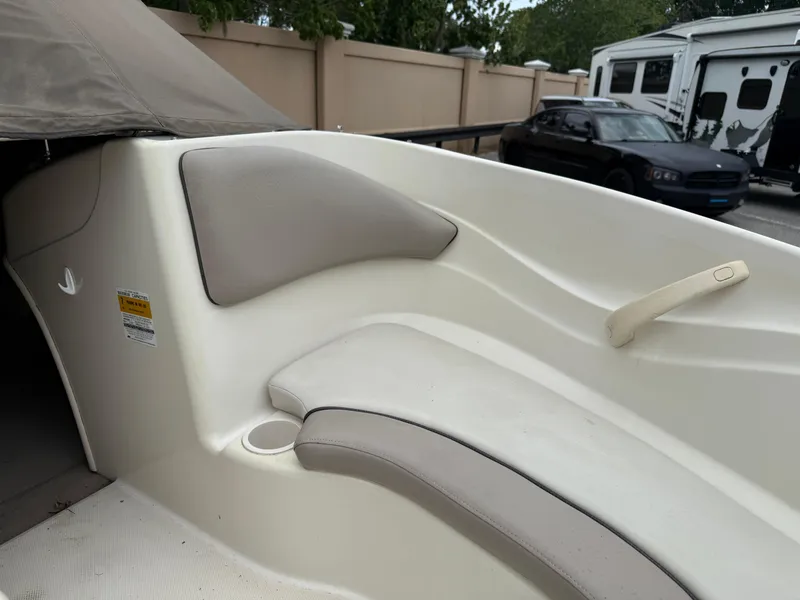 Slide: The Image of 2002 Sea Ray 176 Bow Rider interior with beige seating and cup holder. - 20