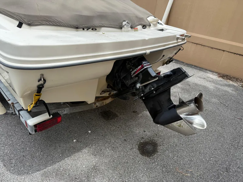 Slide: The Image of 2002 Sea Ray 176 Bow Rider boat with covered stern and visible outboard motor. - 4