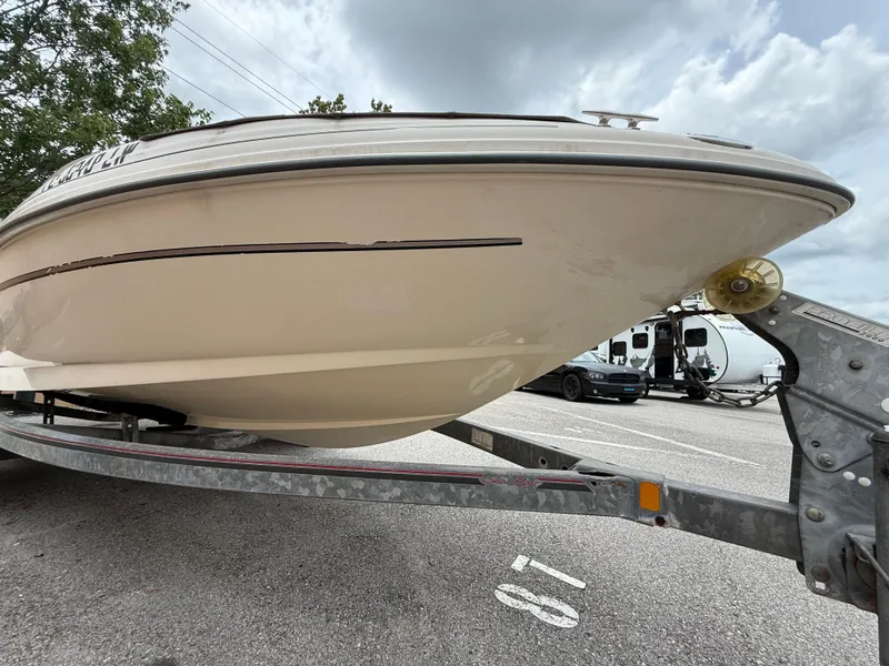 Slide: The Image of 2002 Sea Ray 176 Bow Rider on trailer, parked in a lot under cloudy skies. - 7