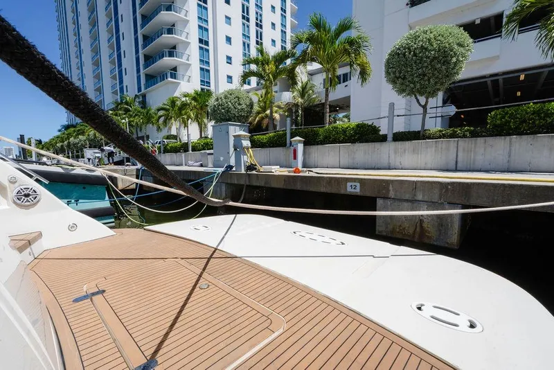 Slide: The Image of 2006 Aicon Flybridge yacht docked near modern high-rise building and palm trees. - 11