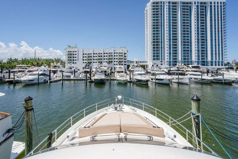 Slide: The Image of Aicon Flybridge 2006 yacht docked in a marina with high-rise buildings in the background. - 14